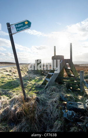 Panneau de signalisation pour sentier public pointant vers le haut avec passage de clôture de style échelle, Peak District, Derbyshire, Grande-Bretagne Banque D'Images