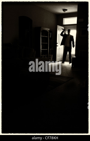 Homme entrant chambre brandissant un couteau. Banque D'Images