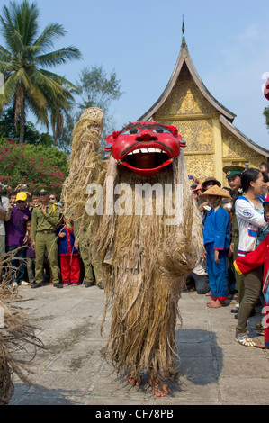 Nyer Pou masqués danser devant une carte SIM d'or de Wat Xieng Thong, mue Nau, Nouvel An Lao (Pi Mai Lao), Luang Prabang, Laos Banque D'Images