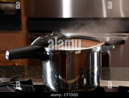 S'échappant des couvercle d'autocuiseur avec reflet de cuisine moderne Banque D'Images