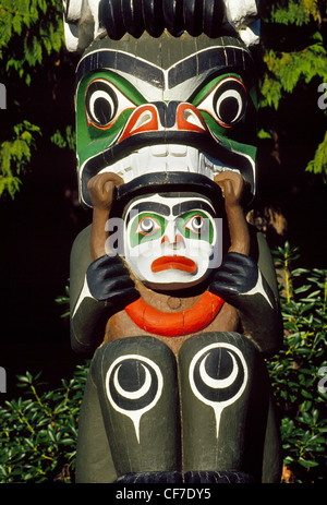 Les figures et les symboles de l'importance pour les peuples des Premières nations sont taillées dans des totems en bois coloré affiché dans Vancouver, Colombie-Britannique, Canada. Banque D'Images