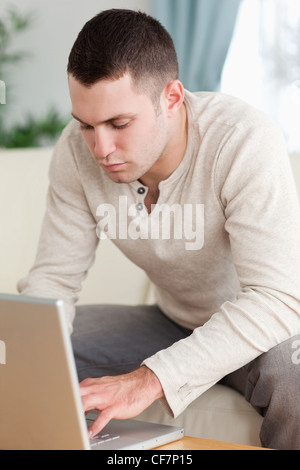 Portrait d'un jeune homme à l'aide d'un ordinateur portable Banque D'Images