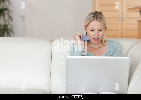 Femme à l'aide d'une carte de crédit pour réserver un vol en ligne Banque D'Images