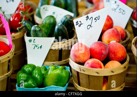 Caisses de poivrons, concombres, de pêches et de tomates à vendre à un marché de producteurs Banque D'Images