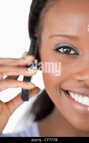 Close up of woman en utilisant son téléphone sur fond blanc Banque D'Images