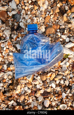 Bouteille en plastique bleu échouée sur la plage Banque D'Images