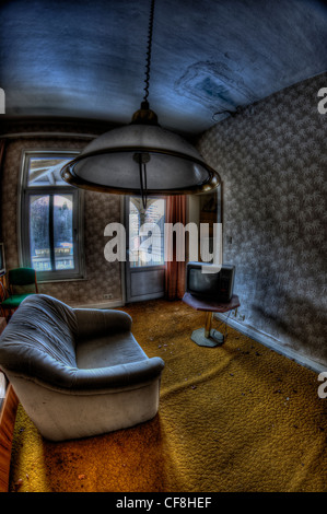 Intérieur de l'hôtel désaffecté près de la frontière avec l'Allemagne de l'intérieur de la télévision et canapé gris lumière plafond Banque D'Images