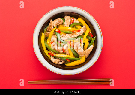 Poulet frit avec capsicum sur red table cloth shoot en studio Banque D'Images