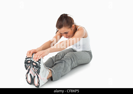 Jeune femme faisant s'étend d'entraînement avant Banque D'Images