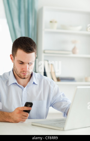 Businessman reading text message dans son homeoffice Banque D'Images