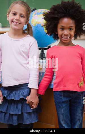 Portrait d'écolières holding hands Banque D'Images