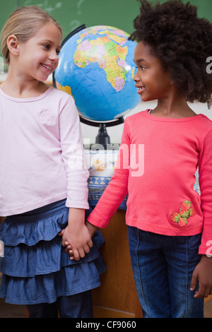 Portrait of smiling ecolières holding hands Banque D'Images