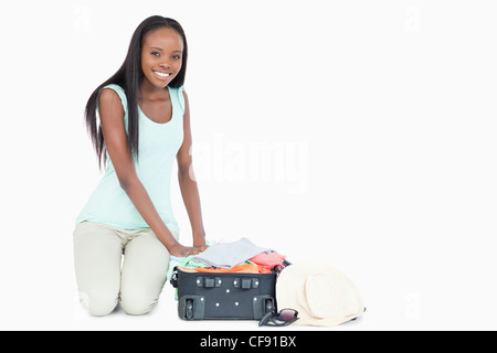 Jeune femme sa valise d'emballage Banque D'Images
