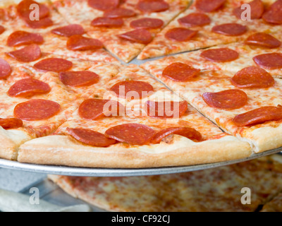 Pepperoni Pizza sur un présentoir sur un comptoir dans un salon d'apizza Banque D'Images
