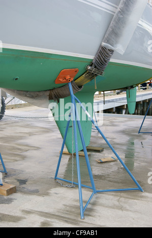 Voilier dans le harnais d'un ascenseur de voyage reposant sur un bateau au chantier naval de Front Street, Belfast, Maine. Banque D'Images