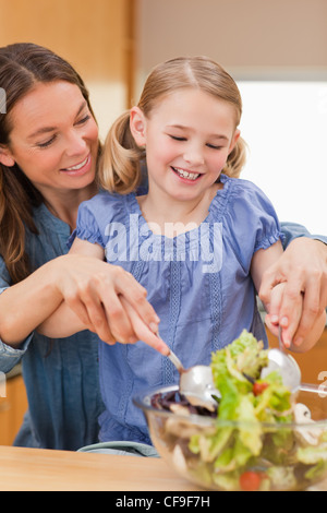 Portrait d'une mère de préparer une salade avec sa fille Banque D'Images