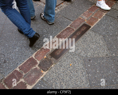 Franchissant la ligne marquant l'emplacement du Mur de Berlin, Berlin, Allemagne Banque D'Images