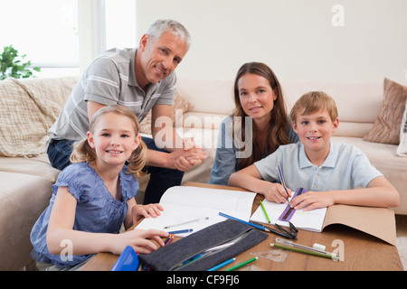 Heureux parents d'aider ses enfants à faire leurs devoirs Banque D'Images