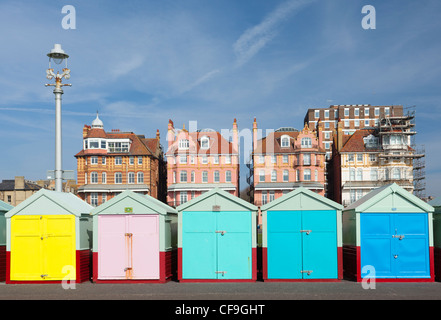Cabines de plage de couleur vive sur Brighton & Hove front de mer avec une période d'amortissement bâtiments derrière Banque D'Images