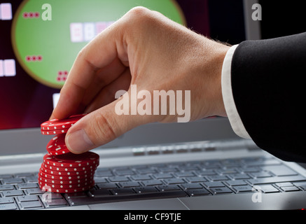 Dvd plaçant des jetons sur un ordinateur portable qui montre un casino en ligne - concept de jeu en ligne ; l'accent sur les jetons Banque D'Images