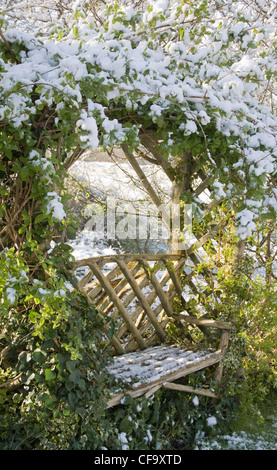 Jardin d'hiver jardin britannique dans Allendale, Kent, UK, donnant sur Romney Marsh banc de jardin plantes grimpantes, après un léger Banque D'Images