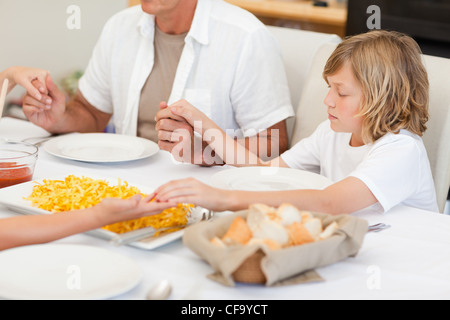 Famille disant une prière avant le dîner Banque D'Images