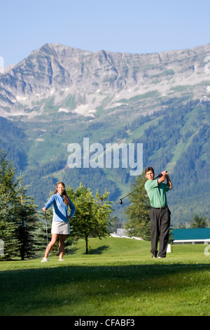 Jeune couple jouer au golf à Fernie Golf and Country Club, Fernie (Colombie-Britannique), Canada. Banque D'Images