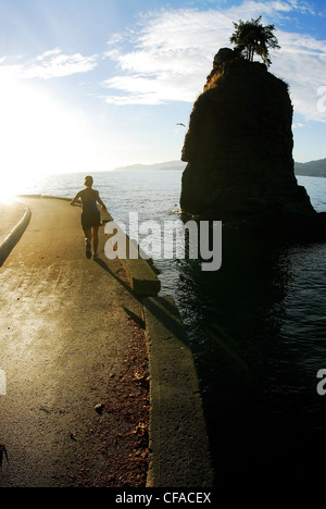 Femme bénéficie d'une journée ensoleillée d'exécution sur le Stanley Park Seawall, près de Siwash Rock, Vancouver, Colombie-Britannique, Canada. Banque D'Images