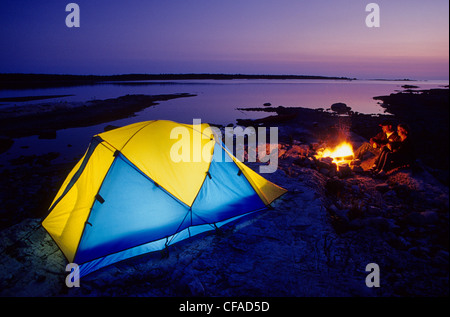 Les campeurs profitez d'un feu de camp au coucher du soleil, sur la rive du lac Huron, près de Tobermory, Ontario, Canada. Banque D'Images