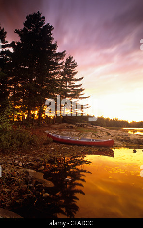 Un canot à terre assis dans un camping, au coucher du soleil, le Parc provincial Killarney, l'Ontario, Canada. Banque D'Images
