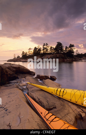 Coucher du soleil, les kayaks sur la plage, le ruisseau Chikanishing, le Parc provincial Killarney, la baie Georgienne, en Ontario, Canada. Banque D'Images