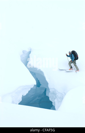 Un skieur rencontre une crevasse de blanc pendant la navigation sur le Glacier Leduc près de Stewart, Yukon, Canada. Banque D'Images