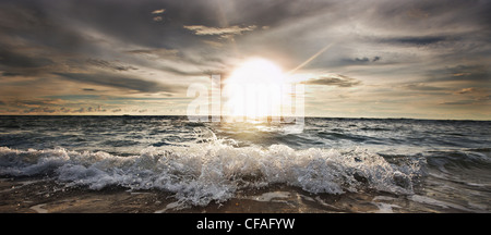 Soleil qui brille au-dessus des vagues rocheuses Banque D'Images