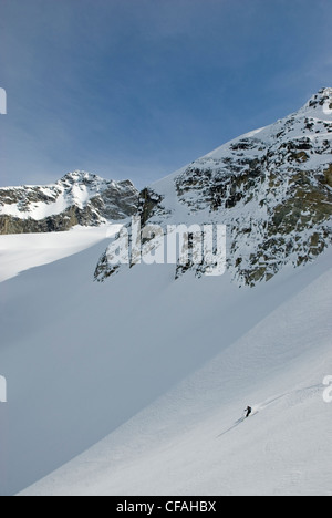 Ski femme ci-dessous la face nord de l'Tszil Mountain, Joffre Lakes Provincial Park, de la chaîne Côtière. La Colombie-Britannique, Canada. Banque D'Images