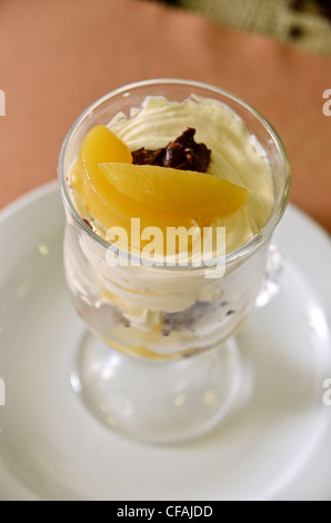 Petit gâteau fraîchement cuit au four avec des tranches d'orange sur une assiette Banque D'Images