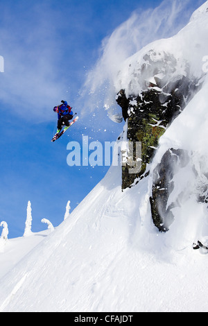 Ski homme sur un rocher dans l'arrière-pays de la chaîne Côtière, Whistler, British Columbia, Canada. Banque D'Images
