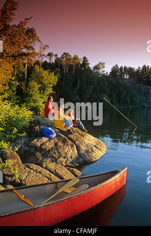 Détente en famille le long du littoral, garçon de pêche, le lac Big Whiteshell, parc provincial de Whiteshell, Manitoba, Canada Banque D'Images