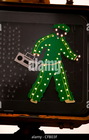 Passage pour piétons avec feux LED homme vert qui a été habillé avec boombox bloqué sur du signe, New York City Banque D'Images