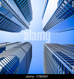 Quatre gratte-ciel de verre highrise building intersection low angle shot à dominante bleu contre un ciel clair Banque D'Images