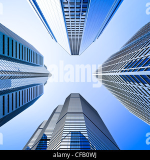 Quatre gratte-ciel de verre highrise building intersection low angle shot à dominante bleu contre un ciel clair Banque D'Images