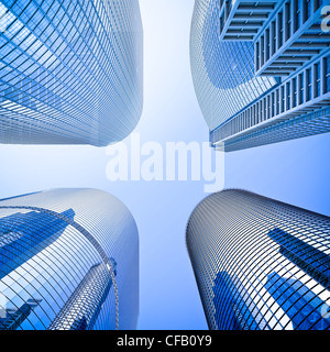 Quatre gratte-ciel de verre highrise building intersection low angle shot à dominante bleu contre un ciel clair Banque D'Images