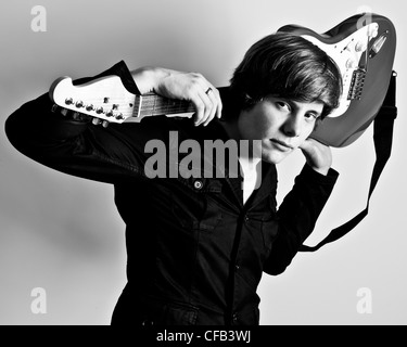 La moitié noir et blanc studio portrait of man wearing black shirt holding electric guitar derrière sa tête sur ses épaules Banque D'Images