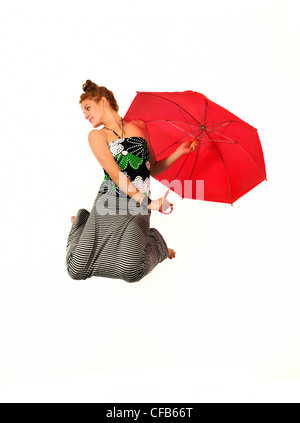 Portrait de jeune beauté sautant avec parapluie rouge isolé sur fond blanc Banque D'Images