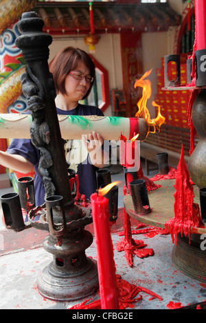 Femme bougie allumée pendant les célébrations du Nouvel An chinois dans le temple pagode à Sibu, Bornéo, Malaisie Banque D'Images