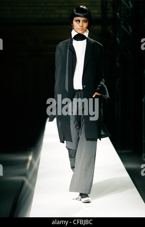 Un modèle féminin noir élégant bob portant une chemise blanche et d'un large collier haut Collier de chien noir, pantalon gris large et un noir Banque D'Images