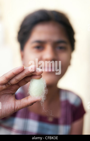 Indian girl holding un cocon de soie entre ses doigts. L'Andhra Pradesh, Inde Banque D'Images