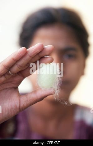 Indian girl holding un cocon de soie entre ses doigts. L'Andhra Pradesh, Inde Banque D'Images