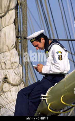 Marin roumain avec téléphone mobile pendant la voile 2005 événement maritime. Amsterdam, Pays-Bas. Banque D'Images