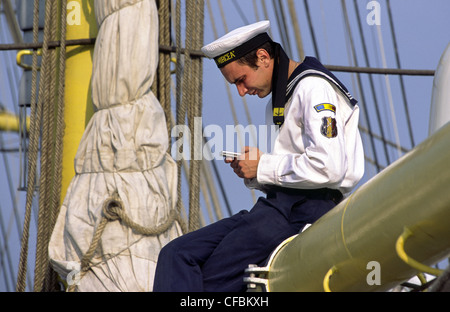 Marin roumain avec téléphone mobile pendant la voile 2005 événement maritime. Amsterdam, Pays-Bas. Banque D'Images