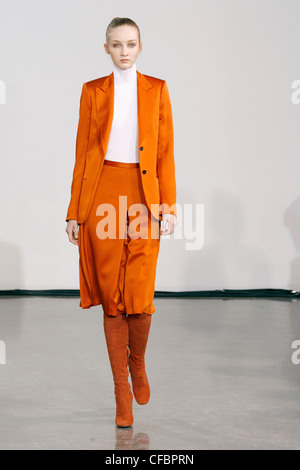 Halston New York Prêt à Porter Automne Hiver veste orange vif breasted unique correspondant à la longueur du genou bottes en daim et jupe Banque D'Images